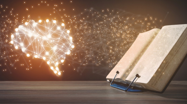 Offenes Buch mit leuchtendem Gehirn links daneben