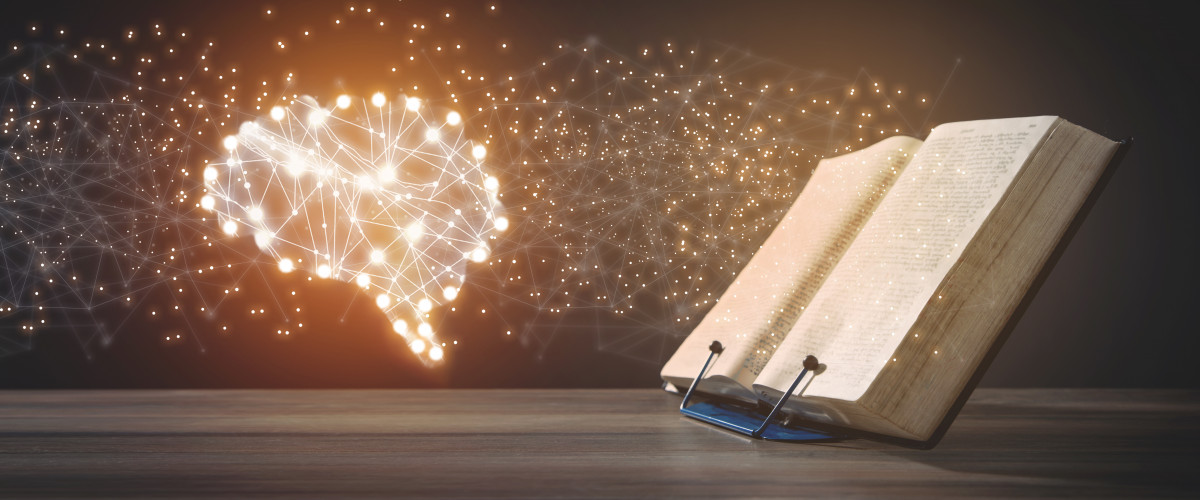 Offenes Buch mit leuchtendem Gehirn links daneben